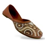 Elegant traditional ethnic footwear from our women's juttis wholesale collection featuring intricate pearl embroidery and crystal embellishments on a flat sole.